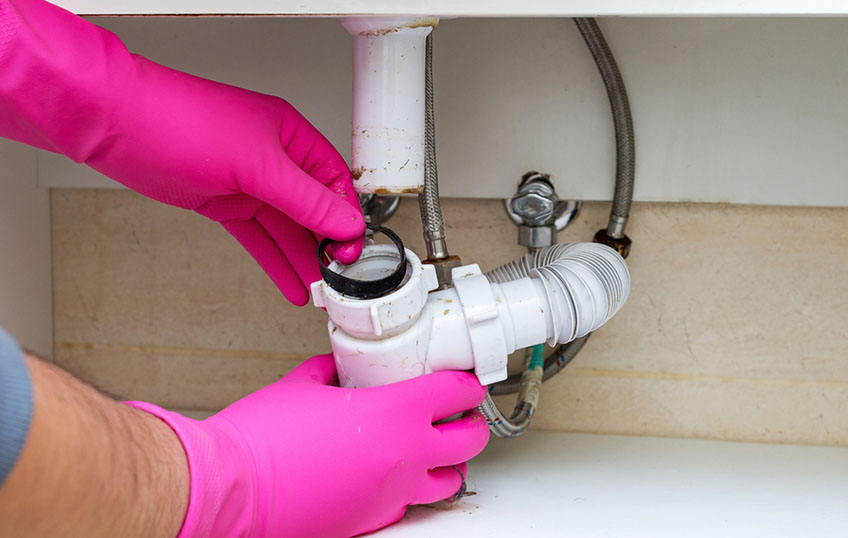 plumber clearing a clogged drain