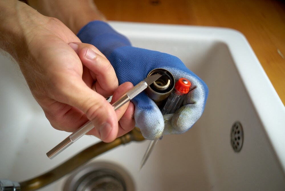 plumber repairing leaking faucet aerator